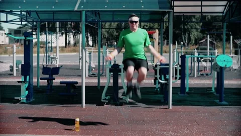 Funny funny man jumping rope in the sports field in sportswear and sports shoes. Stock Footage 146264909