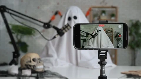 Funny ghost in a white sheet recording a podcast or blog Stock Footage 317250121