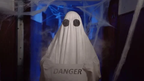 Funny ghost in white sheet showing text danger on camera Stock Footage 314111677