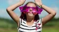 Funny girl in big glasses in shape of stars looks at the camera and makes faces HD Footage