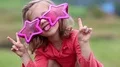 Funny girl in big glasses in shape of stars looks at camera and makes grimaces HD Footage