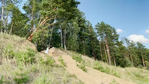 Funny girl bungee jumping in the forest Stock Footage 313475729