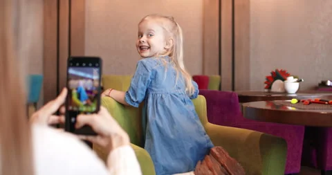 A funny girl dances cutely while her mother takes pictures of her.  Stock Footage 167096834