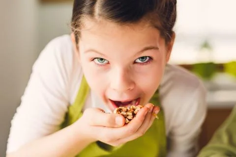 Funny Girl eating walnuts Stock Photos