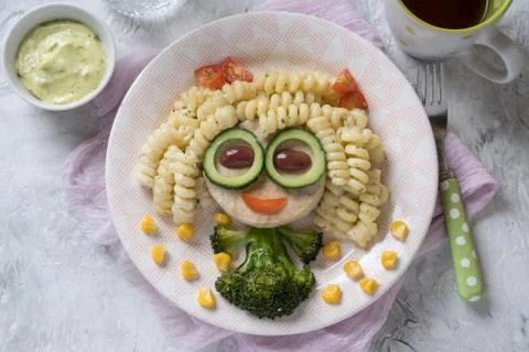 Funny Girl Food Face with Cutlet, Pasta and Vegetables Stock Photos