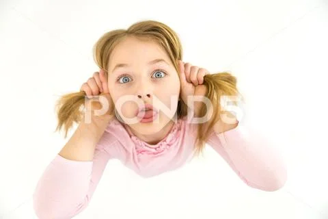 The funny girl show her tongue to the camera. View from above Stock Photos