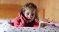 Funny girl with smartphone lies on the bed HD Footage