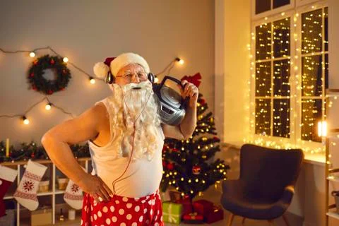 Funny granddad with Santa beard, headphones and boombox having fun on Christmas Stock Photos