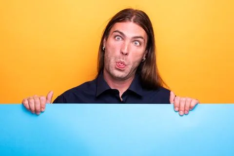 Funny grimace on man face while displayng a blue cardboard Stock Photos
