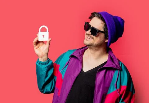 Funny guy in 80s style jacket and sunglasses hold lock symbol on red backgoru Stock Photos