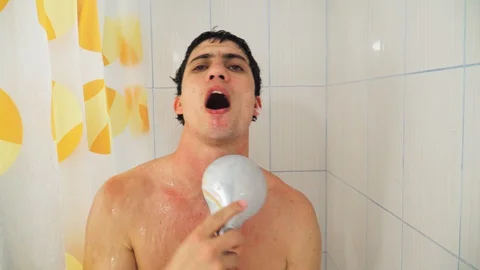 Funny guy in bathroom dancing and singing holding shower and watering with water Stock Footage 129523182