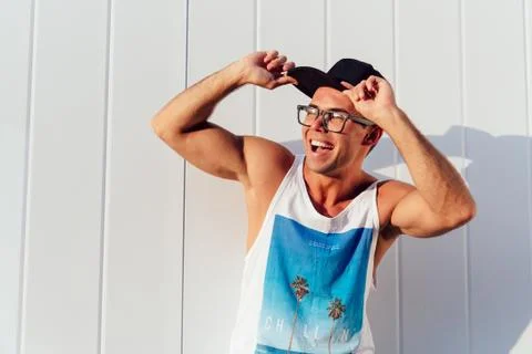 Funny guy in cap and eyeglasses posing near the wall outdoors Stock Photos