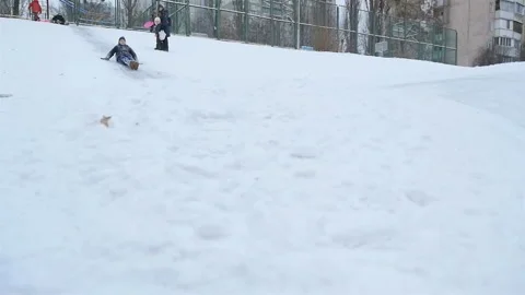 Funny guy goes down a snowy hill. Slow motion 01.10.2020 Ukraine, Kiev Stock Footage 126642044