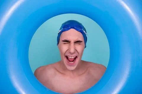 Funny guy with an inflatable ring in the pool. Stock Photos