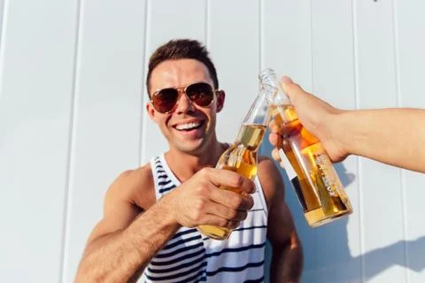 Funny guy making a toast while drinking a beer, outdoors. Stock Photos