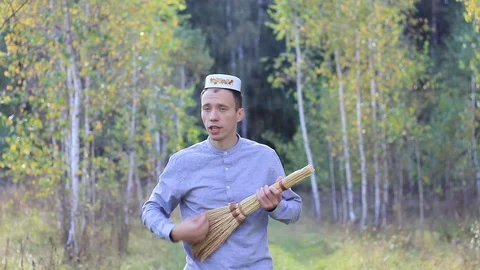 Funny guy with a plate on his head and a broom fooling around and dancing Stock Footage 95847805