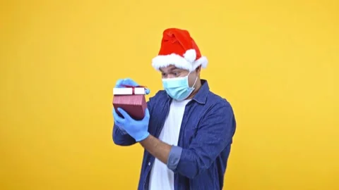 Funny guy secretly open the gift box. He lookin what inside the box. He wearing  Stock Footage 145129628