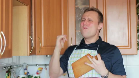 A funny guy singing and playing on a cutting board while cooking food Stock-Footage 86573092