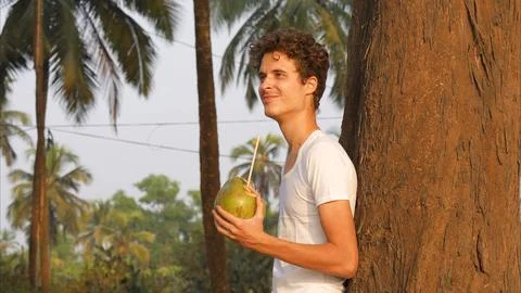 Funny guy at the tree with a coconut in his hands Stock Photos