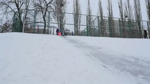 Funny guys go down a snowy hill. Slow motion 01.10.2020 Ukraine, Kiev Stock Footage 126604947