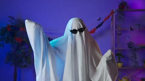 Funny halloween ghost in white sheet with black eyes in dark room wearing Stock Footage 285743174