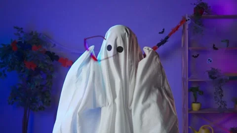 Funny halloween ghost in white sheet with black eyes in dark room dancing cool Stock Footage 285743407