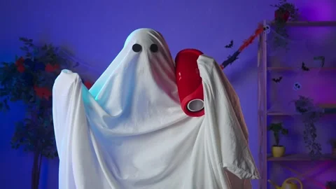 Funny halloween ghost in white sheet with black eyes in dark room dancing with Stock Footage 285744401
