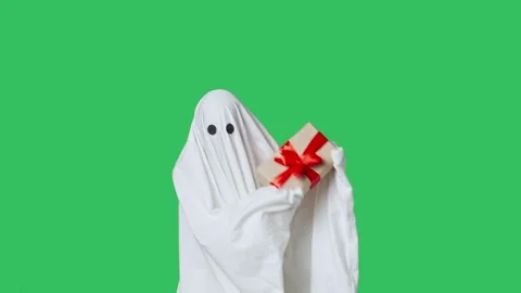 Funny halloween ghost in white sheet holding gift box, happy expression Stock Footage 285747230