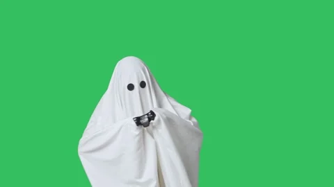 Funny halloween ghost in white sheet plays video game with joystick and wins Stock Footage 285749977