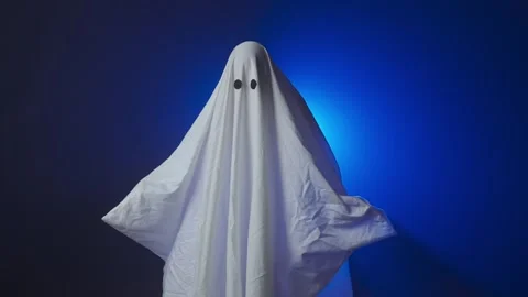 Funny Halloween ghost in white sheet makes scary gestures on background with Stock Footage 285751020