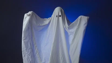 Funny Halloween ghost in white sheet makes scary gestures on background with Stock Footage 285751035