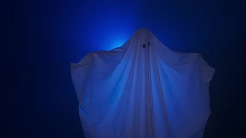 Funny halloween ghost in white sheet silhouette moving under ray of white light 스톡 동영상 285752037