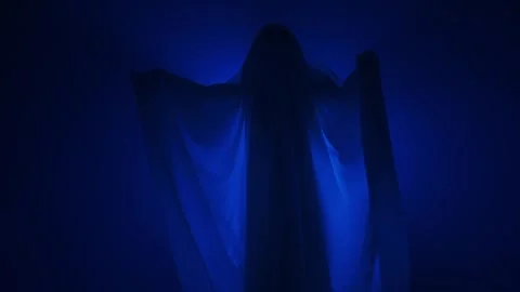 Funny halloween ghost in white sheet silhouette moving under ray of white light Stock Footage 285752316