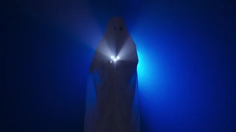 Funny halloween ghost in white sheet silhouette with skull lighted with Stock Footage 285752970