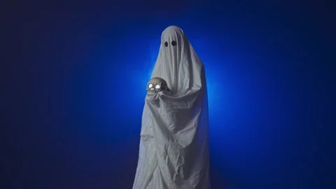Funny halloween ghost in white sheet silhouette with skull lighted with Stock Footage 285753087