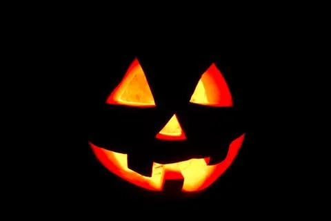 Funny Halloween pumpkin isolated on a black background glow from the inside Photos