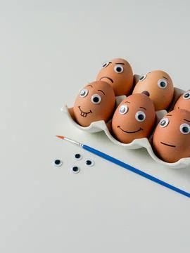 Funny handmade Easter emoji eggs with big eyes on white background close up.. Foto stock
