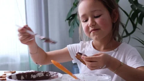 Funny happy girl is dancing while decorates homemade gingerbread with icing Stock Footage 184352488
