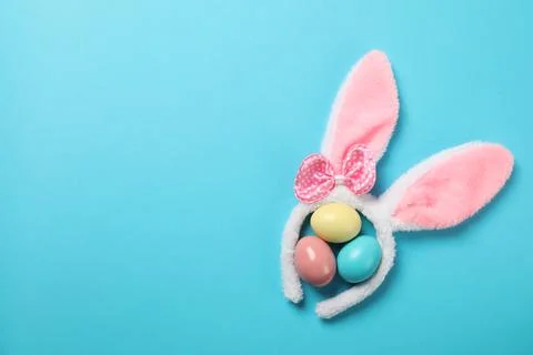Funny headband with Easter bunny ears and dyed eggs on color background, flat 스톡 사진