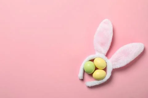 Funny headband with Easter bunny ears and dyed eggs on color background, flat Stock Photos