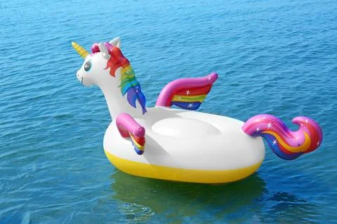Funny inflatable unicorn ring floating on sea water. Summer vacation Foto stock