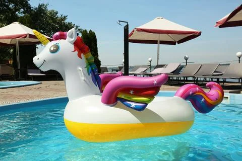 Funny inflatable unicorn ring floating in swimming pool on sunny day, outdoor 스톡 사진