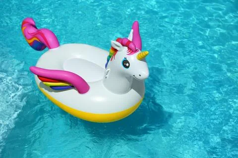 Funny inflatable unicorn ring floating in swimming pool on sunny day. Space f 스톡 사진