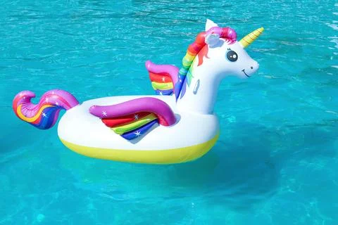 Funny inflatable unicorn ring floating in swimming pool on sunny day 스톡 사진