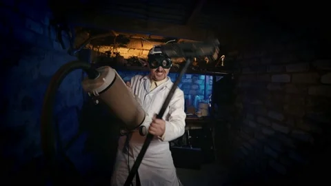 Funny inventor is testing a vacuum cleaner. Clandestine lab Nutty Professor. Stock-Footage 154094058