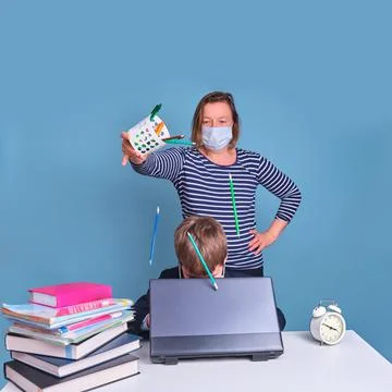 Funny junior boy in school uniform at his desk with laptop, problems of remot Stock Photos