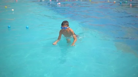 Funny kid boy slow motion swimming in swimming pool on summer time Video stock 106306222