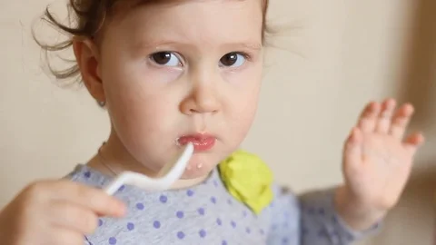 Funny kid eats food with a spoon. Stock Footage 73918128