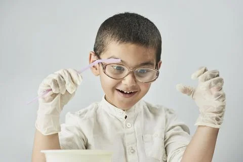Funny kid making experiments at the workshop and exploring the world of Stock Photos
