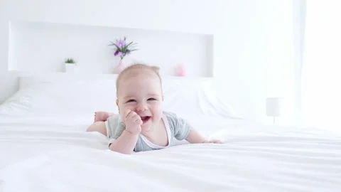 Funny kid toddler lying bed playing laughter nursery house Video stock 165675902